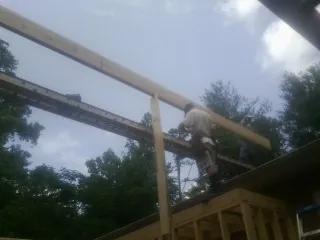 Carpenter setting a ridge beam over a new addition frame — Ice Dam Removal by Roofing Brothers in East Berne