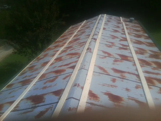 Rusted metal roof panels with new wood purlins before replacement — Storm Damage Roof Repair in East Berne by Roofing Brothers