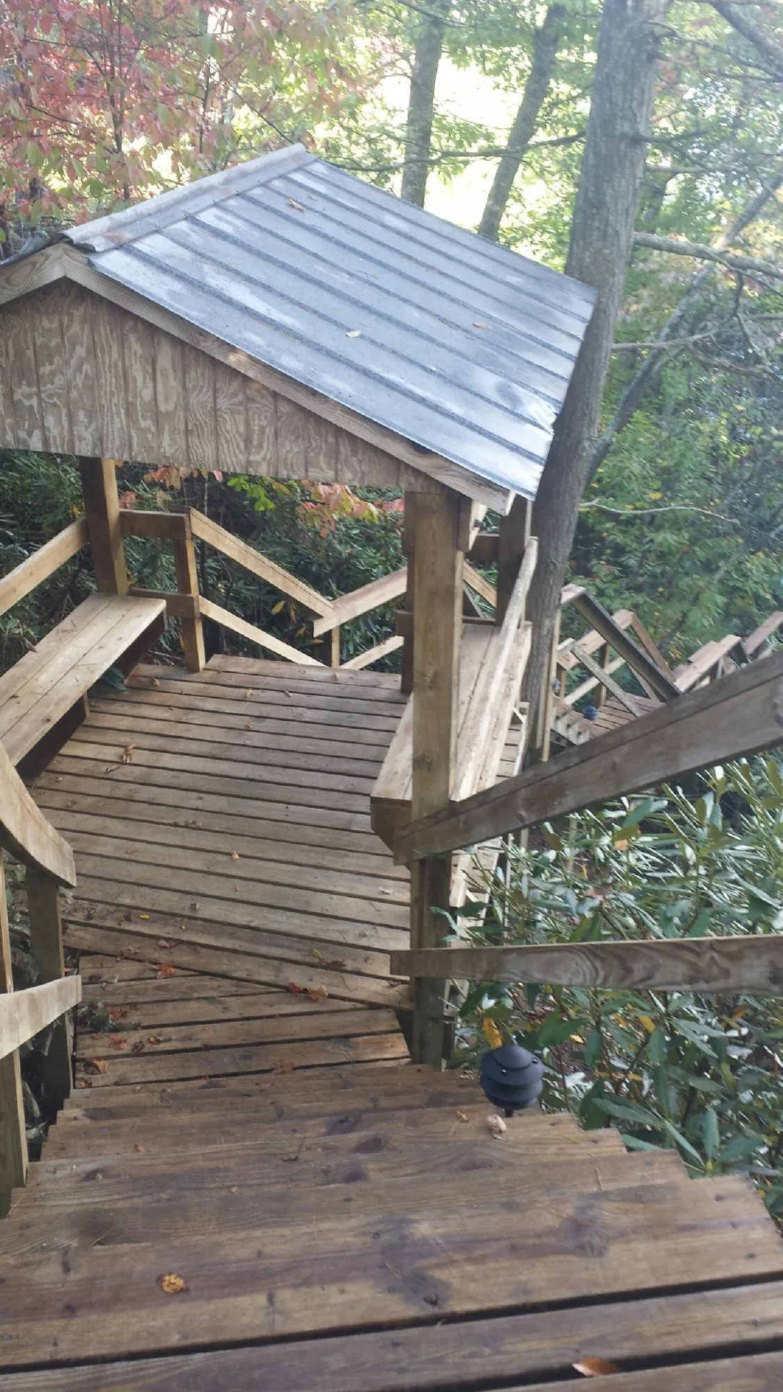 Metal roofed shelter over wooden steps on a wooded walkway — Skylight Repair & Installation work by our crew in East Berne