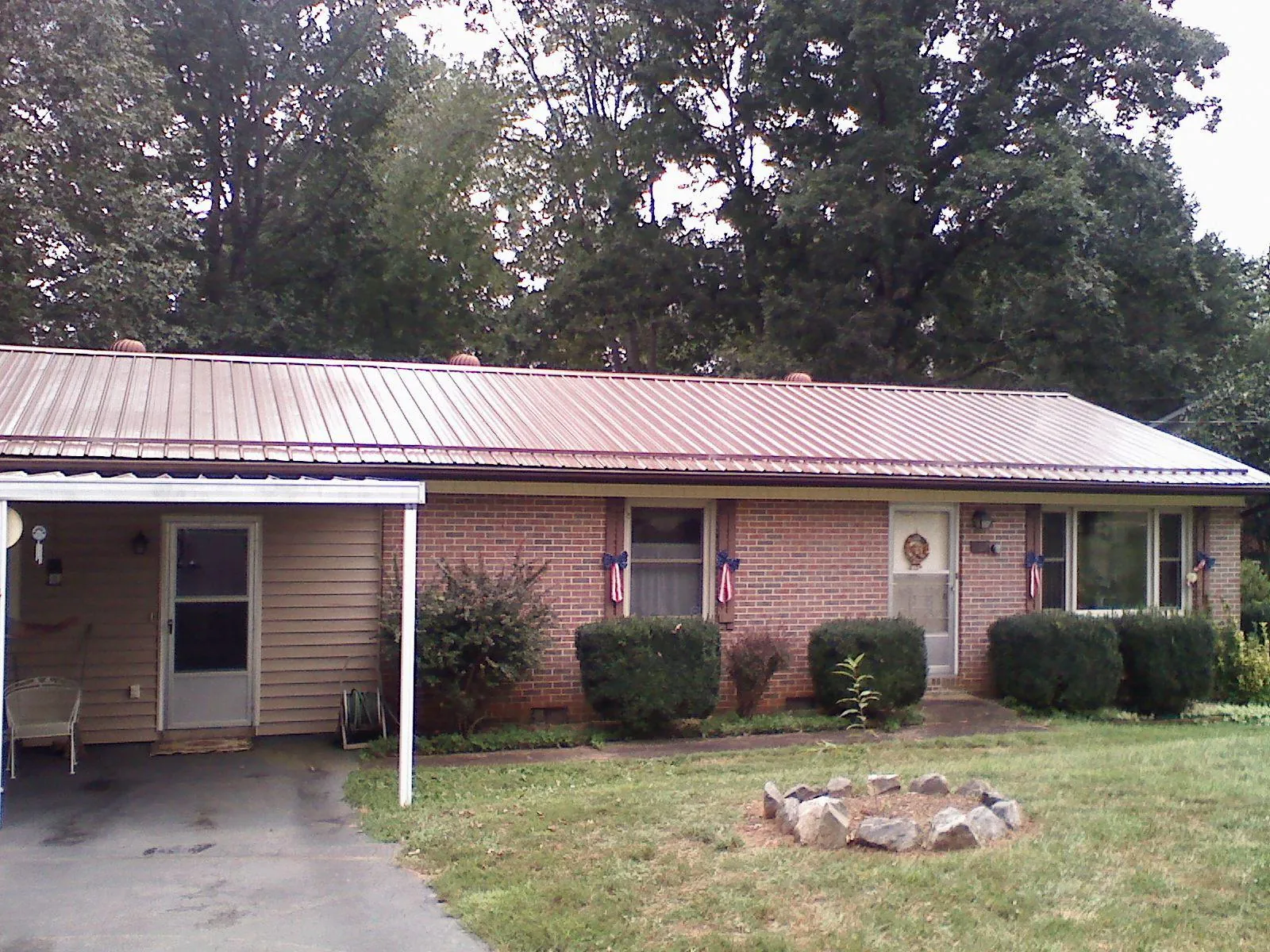 Bronze metal roof and carport on a brick ranch home — Roof Repair work by our crew in East Berne